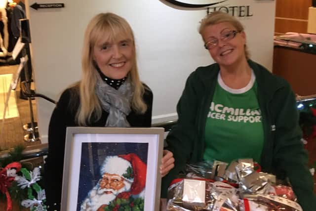The Inn on The Prom duty manager Debbie Spencer, holding one of her diamante pictures, with Macmillan Fundraising Manager, Louise Osgood, who is holding a hamper