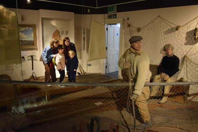 A family observes one of the exhibits at Fleetwood Museum