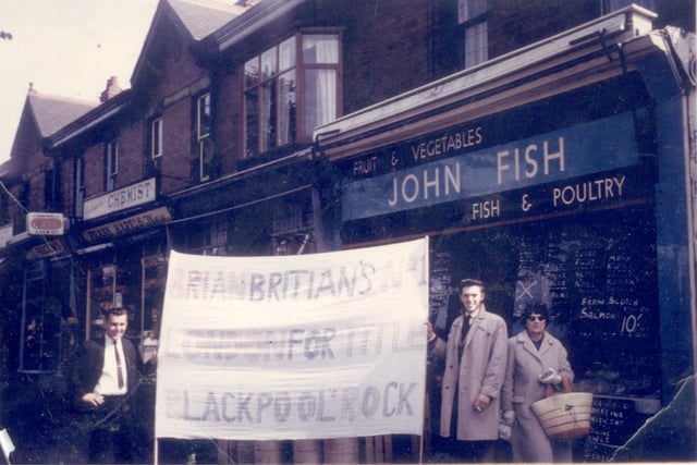 John Fish holds a boxing banner with friend Pete Standring outside his parents shop in Whitegate Drive