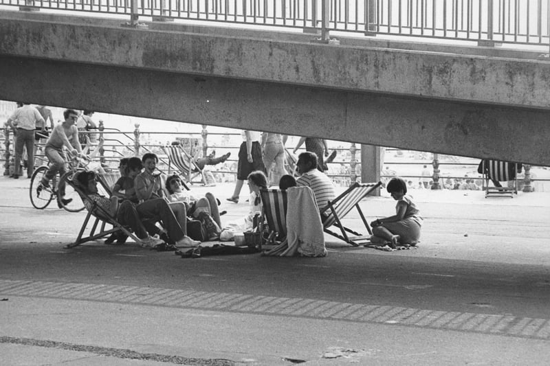 This is a cracking pictures of a family seeking shade under the footbridge on Blackpool seafront
