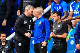 Neil Critchley shakes the hand of Posh boss Grant McCann