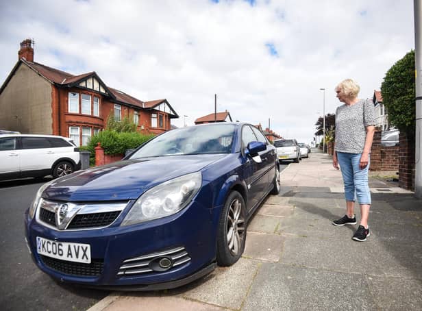 Jo Murray with the car that has been abandoned outside her house for almost two years