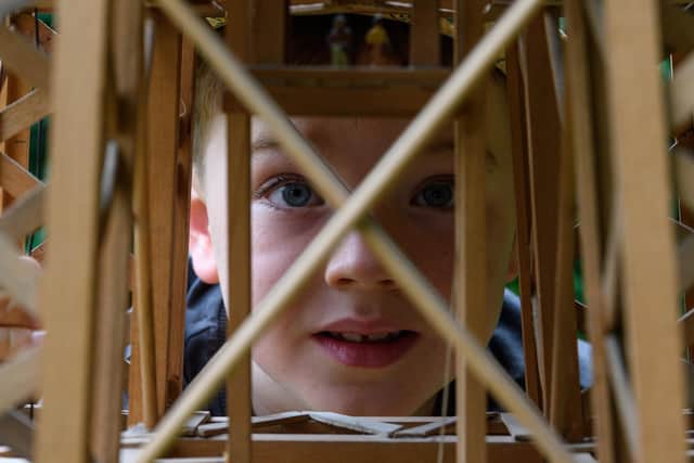 Charlie Barratt peeks through the wooden frame of his newly donated Blackpool Tower replica. Photo: Kelvin Stuttard