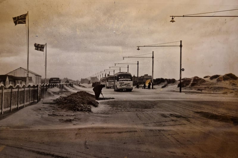 The caption on the back of this photo says - 'Under an angry sky, the high winds were still sweeping sand from the dunes across the road at Squires Gate as workmen fought to keep the thoroughfare clear' This was September 26 1952
