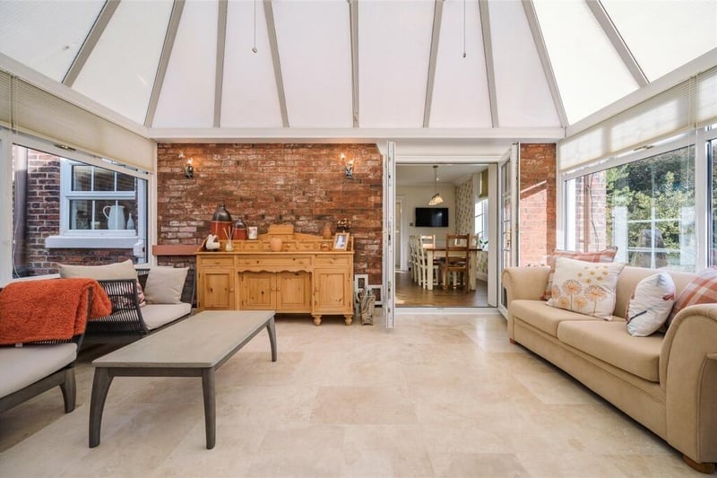Double doors from the kitchen open into a light and airy conservatory which has exposed brick walls