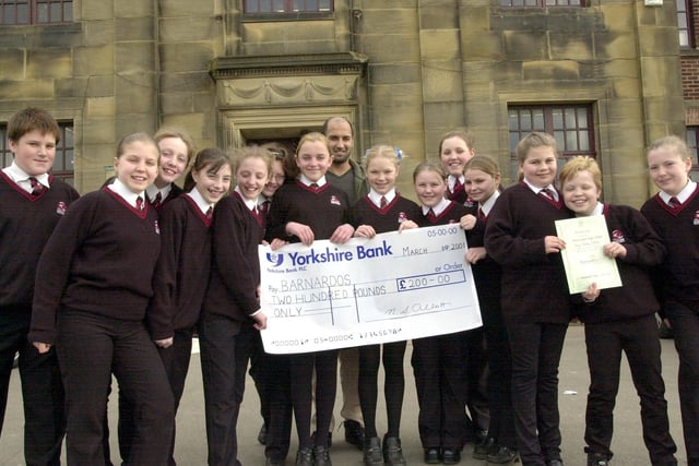 Pupils from Morecambe High School's Cookery Club who raised £200 by baking cakes and biscuits for Barnardo's 'Big Bake' presenting the cheque to Area Fund Raiser for West Lancashire and Cumbria Mehmood Laly (back)