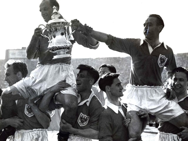 Harry Johnston and Stanley Matthews are carried shoulder high with the cup