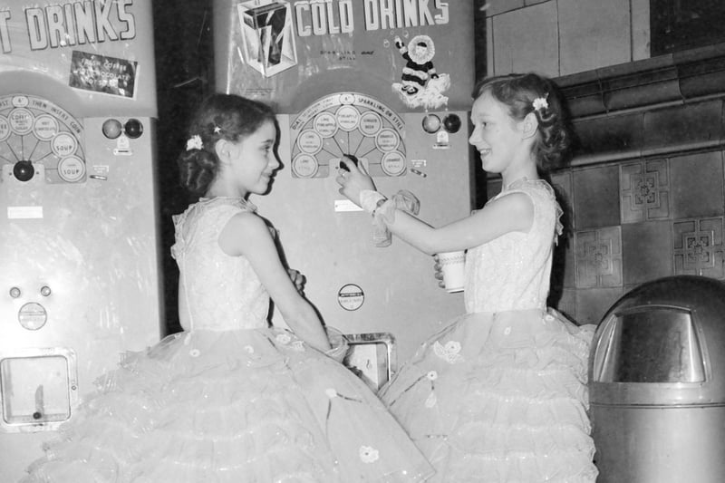 Two thirsty competitors at the Blackpool Dance Festival for Juniors at the Empress Ballroom try out the drinks machine, 1959