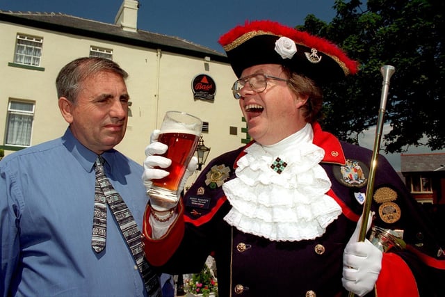 Manager of the Raikes Hotel, Keith Lawton, looks on with trepidation as Town Crier Barry McQueen carries out the ancient ritual 'tasting of the ale'. Tradition apparently dictates that if the Crier deems the ale poor then the landlord is consigned to the stocks and public humiliation