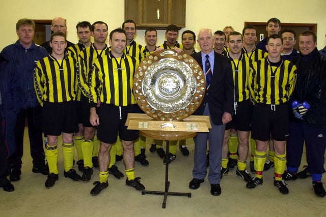 Kirkham and Wesham FC received the West Lancashire Football League premiership trophy from League President Derek Procter. Picture shows the team, led by captain David Gough, accepting the shield