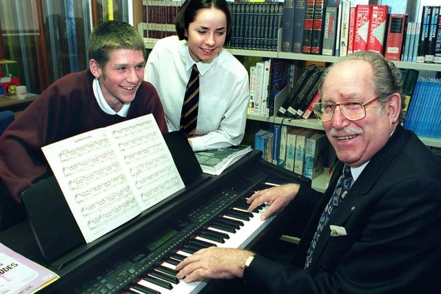 Friends of Palatine chairman Terry Dalton tries out the new Clavinova , which he presented on behalf of  the Friends, to Palatine High School. Watching him are young musicians Paul Jones and Louise Smith, 1998
