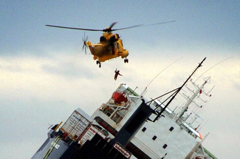 A Royal Air Force helicopter winches a man onto the deck of the Riverdance
