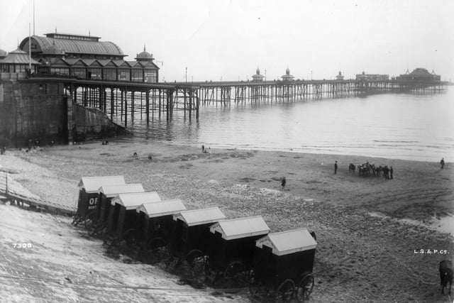 Bathing machines lined up on the beach in front of the North Pier, Blackpool in 1900