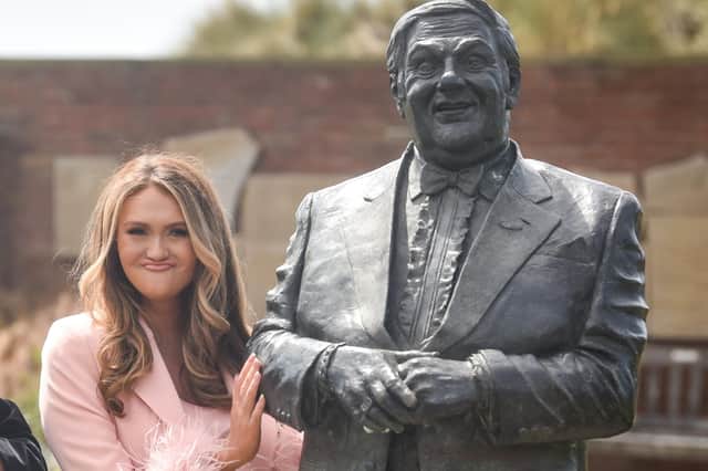 Charlotte Dawson with the statue of her dad Les Dawson statue in St Annes. In this photo Charlotte is pulling the same facial expression her dad was so famously loved for