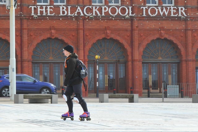 A member of the public takes their daily exercise on the Comedy Carpet in front of the Blackpool Tower