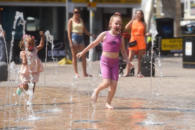 Midday in Blackpool on the hottest day of the year - seven-year-old Evie Mudd cools off in St John's Square.