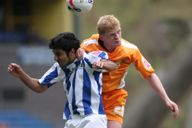Claus Jorgensen gets to grips with Huddersfield's Adnan Ahmed