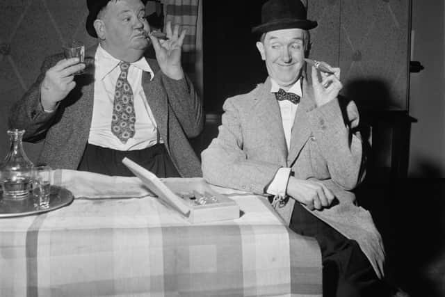 Stan Laurel and Oliver Hardy pause for a cigar in the sketch A Spot Of Trouble in 1952
