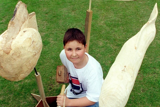 Visitors to the summer fair in 1998 were invited to add their bit to a wooden sculpture of stylized fish, created by sculptor Geoff Whitley, to stand in the school to mark the Millennium. This is 13 year-old Michael McVeigh busy with the chisel