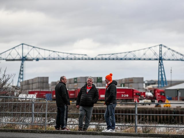 A Blackpool fan strikes up a conversation with Middlesbrough supporters before kick-off