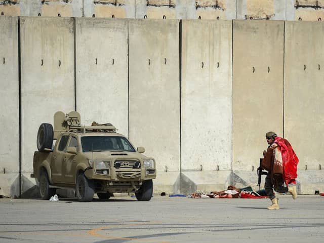 A Taliban Badri special force fighter runs while carrying a blanket at the airport in Kabul on August 31, 2021, after the US pulled all its troops out of Afghanistan