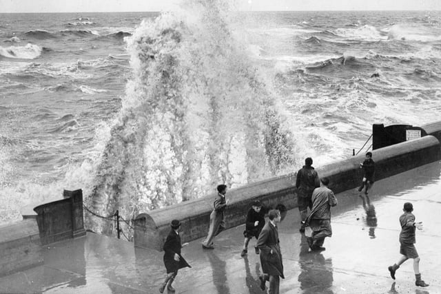 This scene typifies Blackpool's storm weather - rough seas and people dodging waves back in 1946