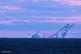 This picture by Marilynne Tomlinson shows just how big the Swiss-owned vessel is, with the behemoth and its giant crane seen lit up as the sun set on the Irish Sea on Wednesday (July 12). (Photo by Marilynne Tomlinson)