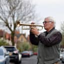 Musician Terry Reaney plays trumpet on his street during the 8pm clap for NHS