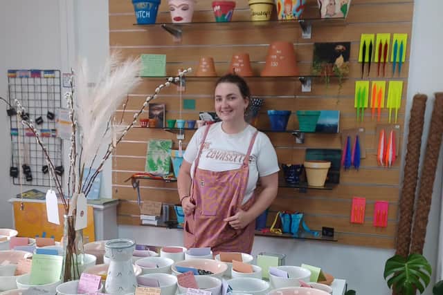 Izzy Durose, 21, infront of a selection of her hand-painted plant pots