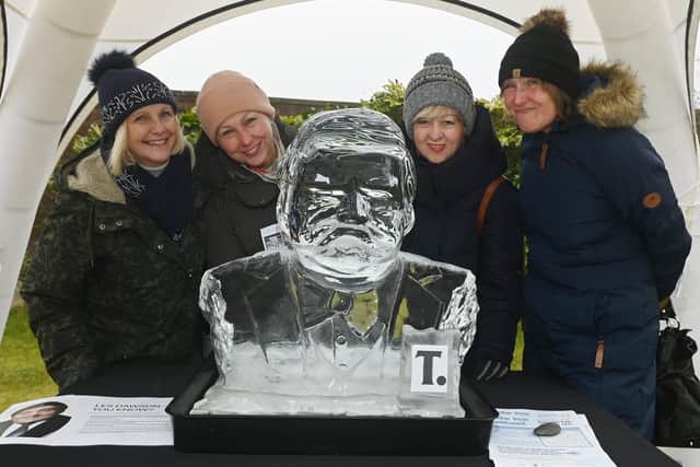 Copying the famous face of comedian Les Dawson next to his ice sculptor bust, part of the trail.  The Fylde Ice Festival 2025, with ice sculpture trail around St Annes with ice carving demonstrations in Ashton Gardens where visitors were encouraged to carve the ice wall, with award winning Glacial Art Ice Sculptors.