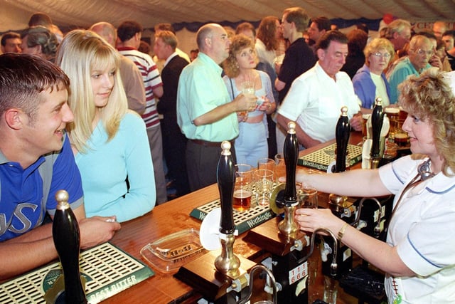 This was the Beer Festival at the Saddle Inn in Whitegate Drive, 1998.  Barmaid Karen Turner serving one of the guest brews