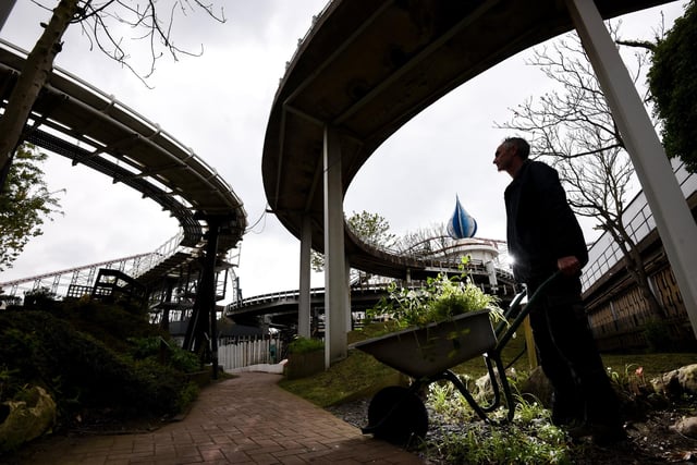 In the shadows of the rollercoasters, Gary Rollinson is pictured at work pushing the wheelbarrow