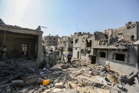 A local citizen searches through buildings which were destroyed during Israeli air raids in the southern Gaza Strip (Photo by Ahmad Hasaballah/Getty Images)