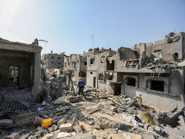 A local citizen searches through buildings which were destroyed during Israeli air raids in the southern Gaza Strip (Photo by Ahmad Hasaballah/Getty Images)