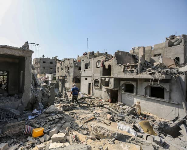 A local citizen searches through buildings which were destroyed during Israeli air raids in the southern Gaza Strip (Photo by Ahmad Hasaballah/Getty Images)