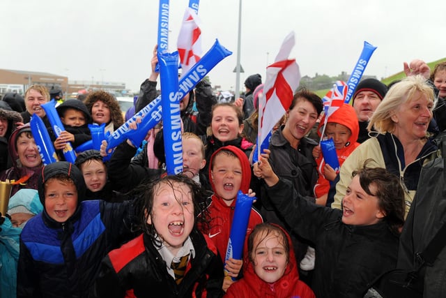 Local school children brave the poor weather to watch the Olympic Flame on the relay