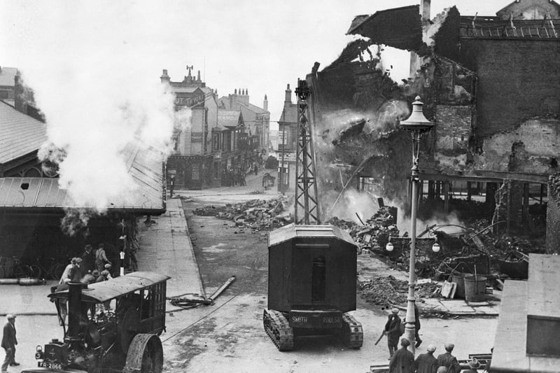 After many attempt the tractor crane and traction engine pull down the huge wall left standing amid the ruins of Boots in 1936 after a huge fire