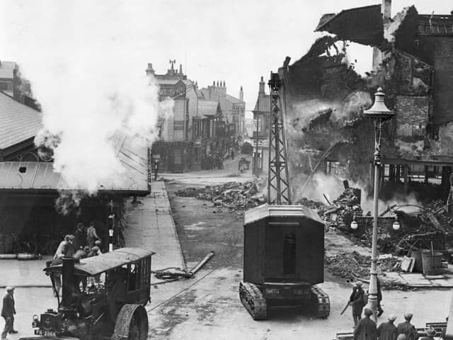 After many attempt the tractor crane and traction engine pull down the huge wall left standing amid the ruins of Boots in 1936 after a huge fire