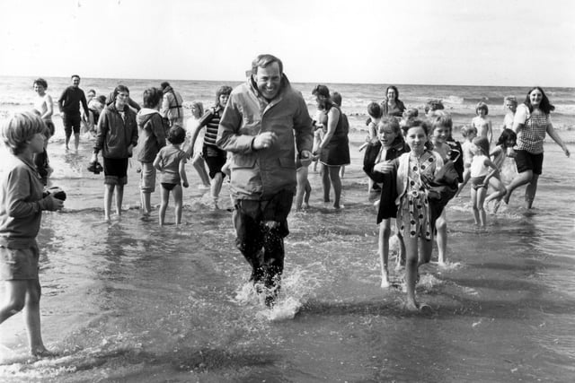 Irish crooner Val Doonican wades ashore on Blackpool Beach in 1974