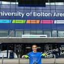 Image Natalie Amber wheelchair user in front of Bolton Arena wearing a blue Motor Neurone DIsease t-shirt
