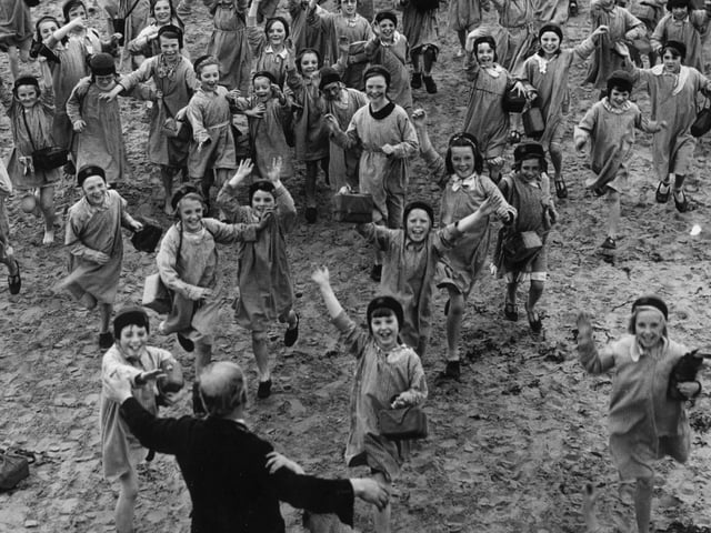 A crowd of happy children run toward Mr Brown, the superintendent of the Blackpool holiday home they were enjoying which offered a sea side break for poor children in the Manchester area
