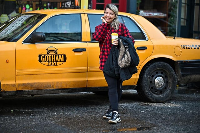 A passer-by poses with a New York style cab (Getty Images)