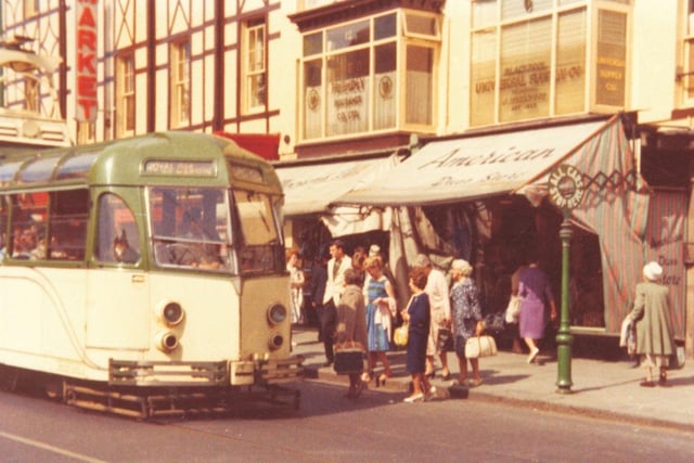 A rare colour photo outside Abingdon Street Market where morning shoppers are waiting for the the tram to Marton