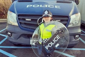 Little Oliver Shorthouse, seen in his riot gear, became a policeman for a day after winning an 'act of kindness' competition