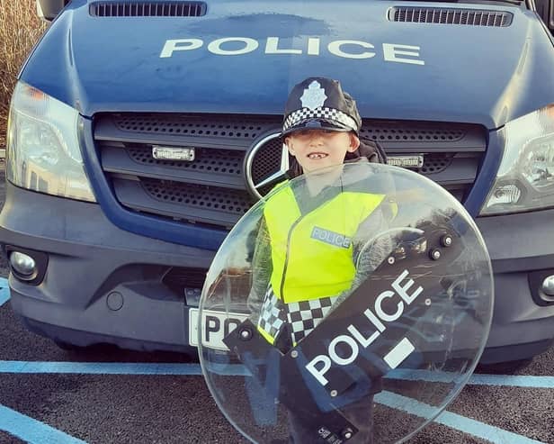 Little Oliver Shorthouse, seen in his riot gear, became a policeman for a day after winning an 'act of kindness' competition