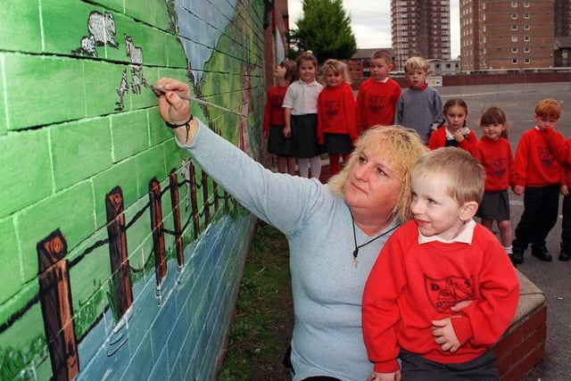Denise Harris painted murals on the playground walls at Devonshire Infant School in 1999. Pictured with her son Eric Mathjer, who was 4, and his classmates