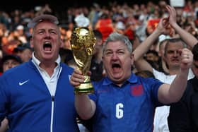 England fans show a replica world cup trophy in the crowd ahead of the international friendly football match between England and Switzerland at Wembley stadium in north London on March 26, 2022. (Photo by Adrian DENNIS / AFP)