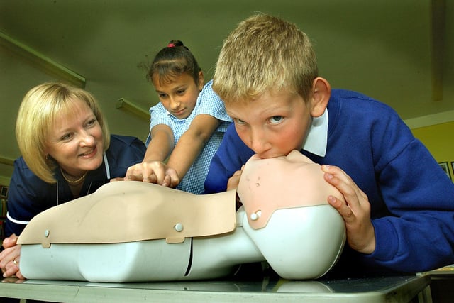 NHS staff demonstrating life-saving techniques at St Cuthbert's Catholic Primary School. Karen Hodgson (Nurse Training Co-ordinator, Fylde Primary Care Trust) watches Nathan Gourley and Basia Sooky (both 10) trying resuscitation techniques, 2003