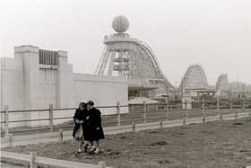 Two young girls stroll across a swathe of undeveloped land at the Pleasure Beach against the backdrop of the Big Dipper. The roller coaster was built by William Strickler at a cost of just £25,000