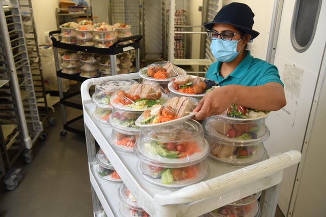 A member of staff piles up the meals ready for delivery
